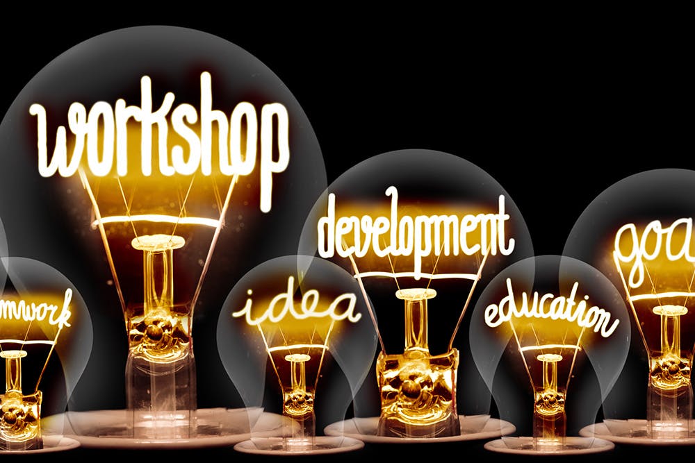 Neon Lightbulbs that say Workshop, idea, development, education, goals