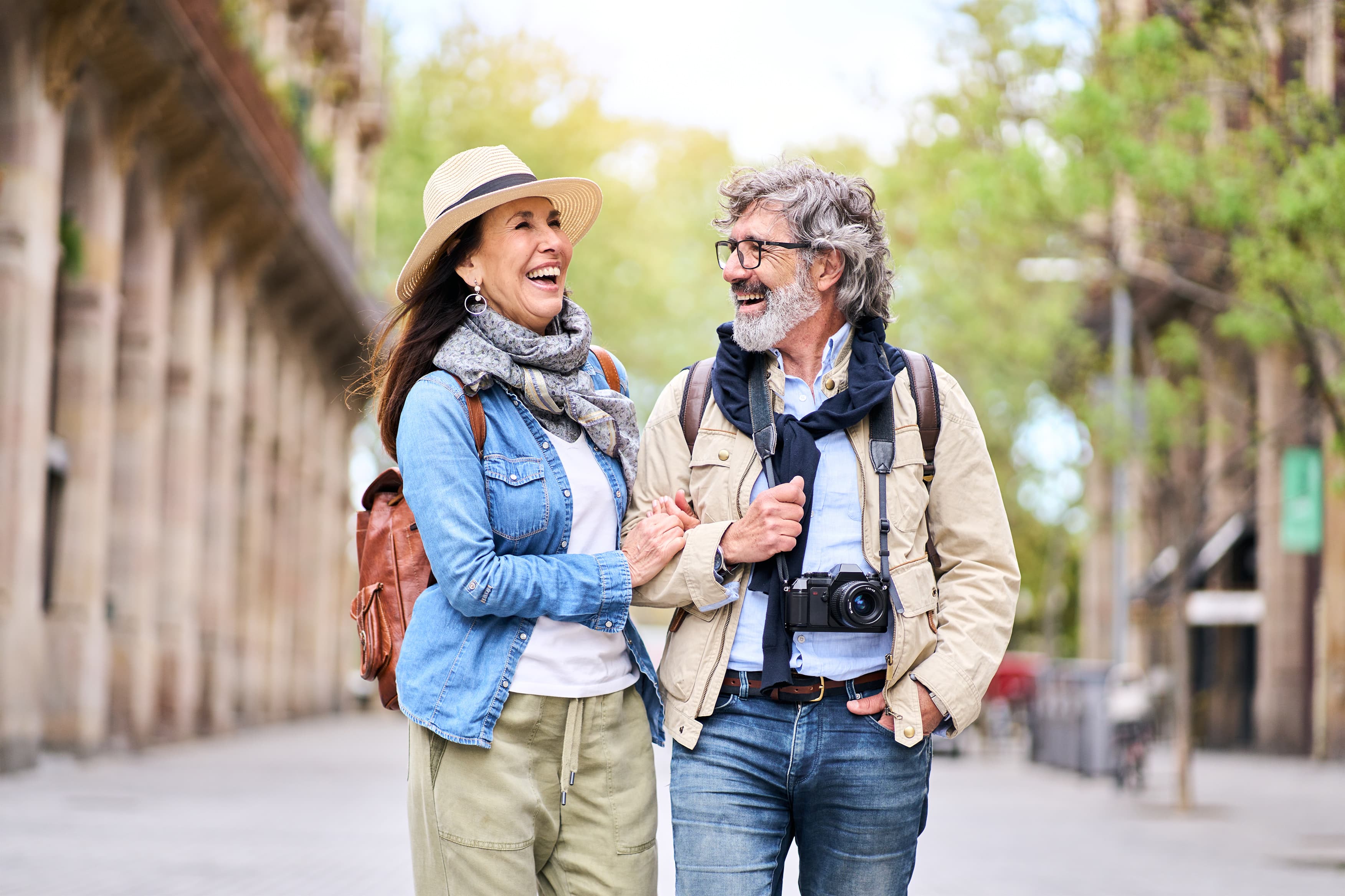 Happy mature couple having fun walking outdoors in city.