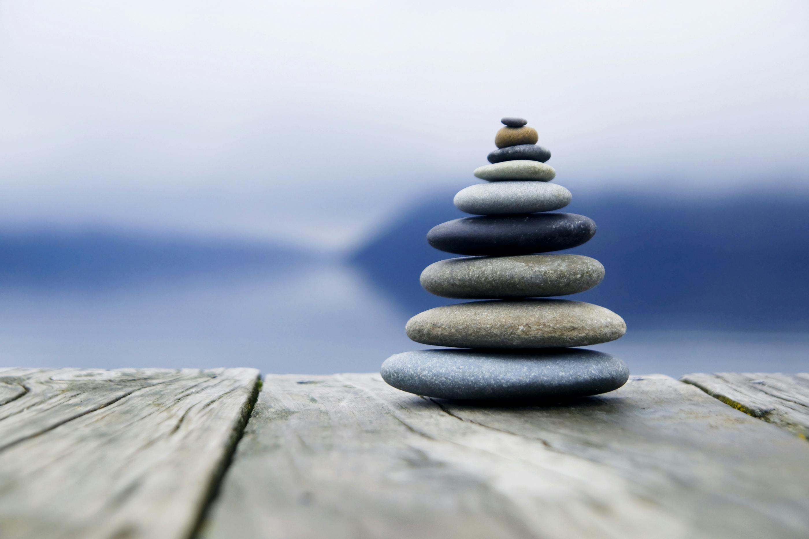 Zen balancing pebbles near a misty lake