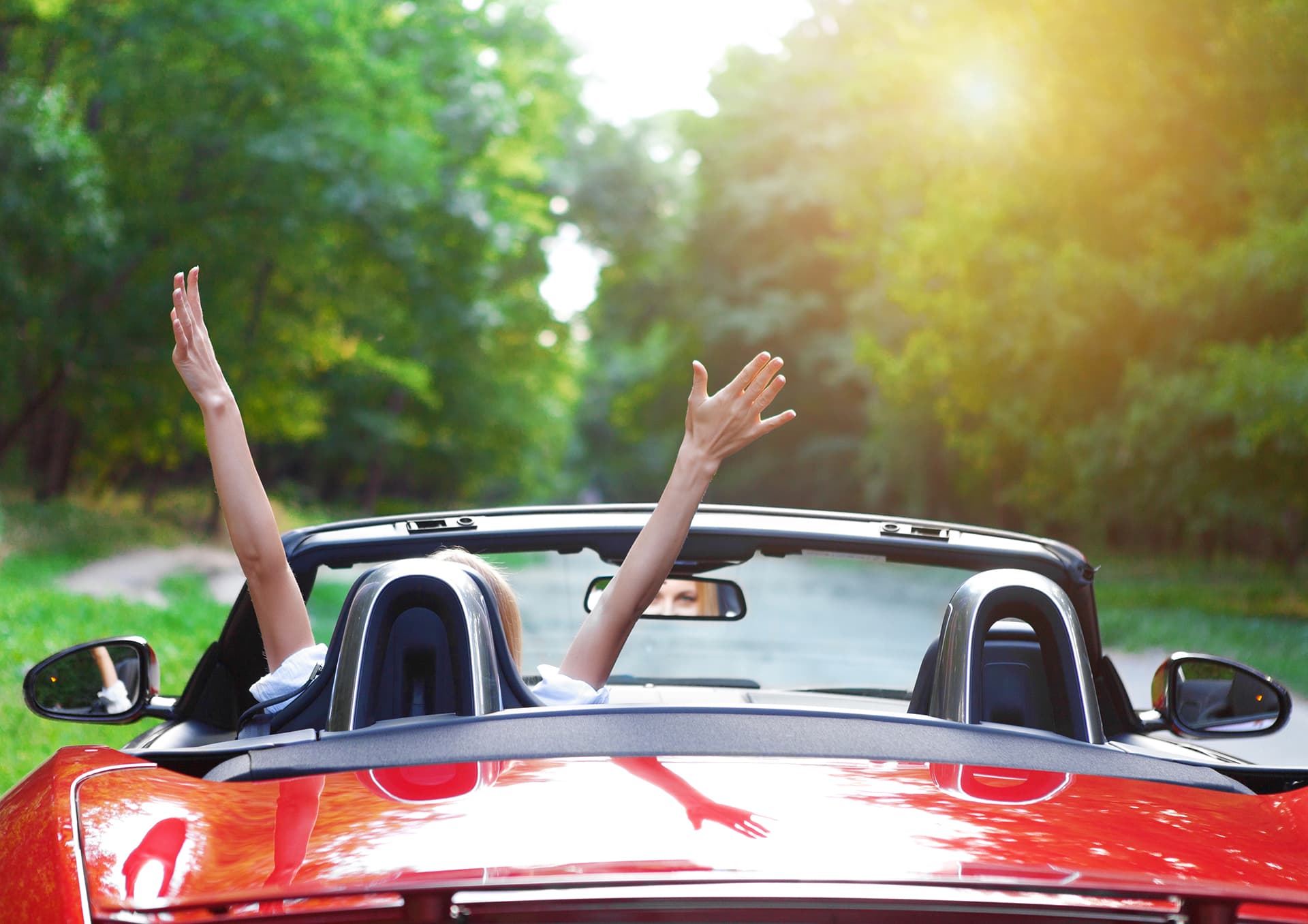 Red convertible, driver with hands raised